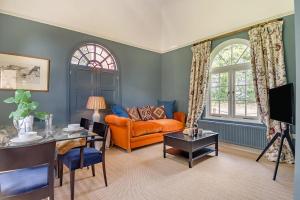 a living room with an orange couch and a table at 1 Bed in Wymondham oc-e32664 in Wymondham