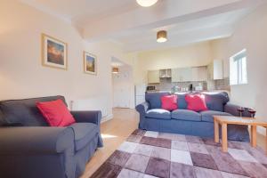 a living room with two blue couches and a table at 1 Bed in Chedgrave oc-2250 in Chedgrave