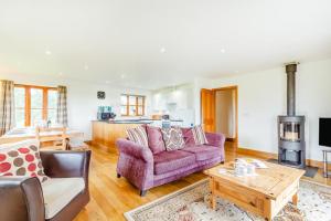 a living room with a purple couch and a table at 3 Bed in Shebbear oc-l32583 in Shebbear