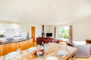 a kitchen and living room with a wooden table at 3 Bed in Shebbear oc-l32583 in Shebbear