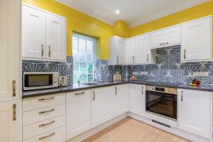 a kitchen with white cabinets and a microwave at 1 Bed in Clatcombe oc-s33309 in Castletown +11 photos