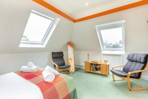 a bedroom with two chairs and a bed and two windows at 1 Bed in Clatcombe oc-s33309 in Castletown