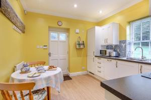 a kitchen with yellow walls and a table and chairs at 1 Bed in Clatcombe oc-s33309 in Castletown