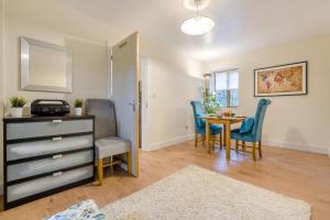 a living room with a dining room table and blue chairs at 1 Bed in Rolvenden oc-c33657 in Rolvenden
