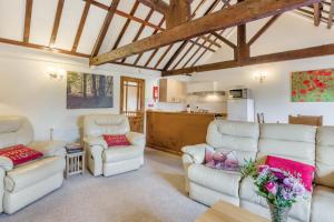 a living room with white couches and a kitchen at 2 Bed in Smallburgh oc-m33732 in Dilham