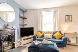 a living room with a blue couch and a tv at 2 Bed in Tenby oc-pw1031 in Tenby