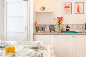 a kitchen with a table with plates and wine glasses at 2 Bed in Tenby oc-pw1031 in Tenby +9 photos
