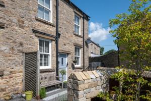 a stone house with a bench in front of it at 3 Bed in Carperby oc-ds058 in Carperby
