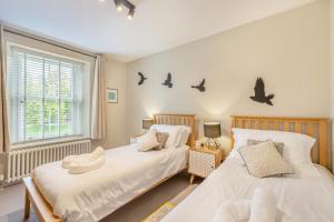 two beds in a bedroom with birds on the wall at 3 Bed in Carperby oc-ds058 in Carperby