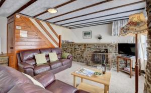 a living room with a leather couch and a fireplace at 2 Bed in Westward Ho oc-n0987 in Westward Ho