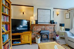 a living room with a fireplace and a television at 2 Bed in Dennington oc-b28010 in Dennington