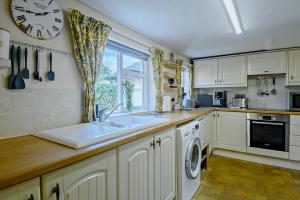 a kitchen with a sink and a clock on the wall at 2 Bed in Dennington oc-b28010 in Dennington +5 photos