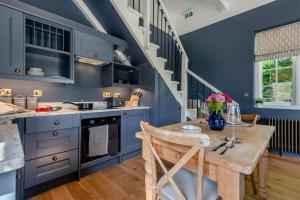 a kitchen with blue cabinets and a wooden table at 1 Bed in Tollard Royal oc-t29453 in Tollard Royal +4 photos