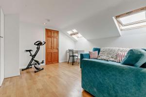 a living room with a blue couch and a treadmill at 5 Bed in St. Merryn oc-t27899 in Saint Merryn