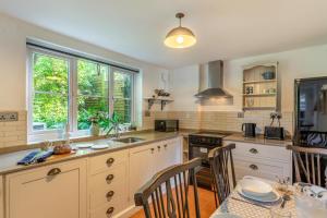a kitchen with white cabinets and a table with chairs at 2 Bed in Chideock oc-h29331 in Chideock