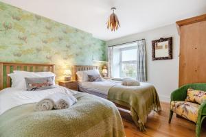 a bedroom with two beds and a chair and a window at 3 Bed in Appersett oc-ds944 in Appersett