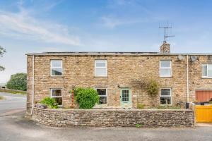 a brick house with a stone fence in front of it at 3 Bed in Appersett oc-ds944 in Appersett