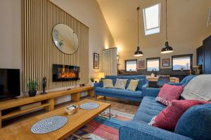 a living room with blue couches and a fireplace at Riverside Park 5 in Keswick
