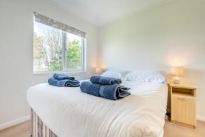 a bedroom with a large white bed with towels on it at 3 Bed in St. Merryn oc-k30138 in Saint Merryn