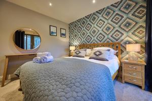 a bedroom with a large bed and a mirror at Riverside Park 5 in Keswick