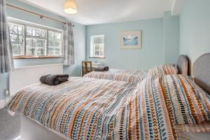 a bedroom with a bed with a colorful comforter at 3 Bed in Scethrog oc-h30013 in Scethrog