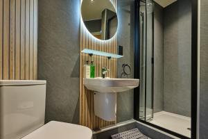 a bathroom with a sink and a toilet and a mirror at Riverside Park 5 in Keswick +41 photos
