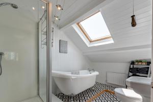a bathroom with a tub and a toilet and a window at 3 Bed in Port Talbot oc-b30321 in Port Talbot +24 photos