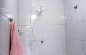 a bathroom with a shower with a pink towel at SUÍTE em casa FRENTE AO MAR - Acesso à PRAIA, CHURRASQUEIRA, GARAGEM e WI-FI 80mbps - Ambiente Privativo - Itanhaém-SP in Itanhaém +22 photos
