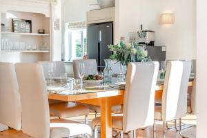 a dining room with a wooden table and white chairs at 5 Bed in Rock oc-m33185 in Roche