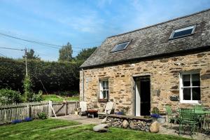 a stone cottage with a table and chairs in the yard at 2 Bed in Dunkeld oc-i30992 in Dunkeld