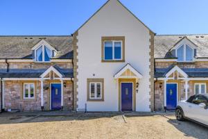 a house with blue doors and a car parked in front at 2 Bed in Beadnell oc-s30910 in Beadnell