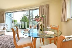 a dining room with a glass table and chairs at 3 Bed in Llanbedrog oc-gerddi in Llanbedrog