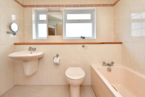 a bathroom with a toilet and a sink and a tub at 3 Bed in Llanbedrog oc-gerddi in Llanbedrog
