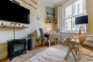 a living room with a fireplace and a table with a desk at 1 Bed in Fowey oc-m27634 in Fowey