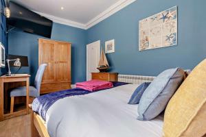 a bedroom with blue walls and a bed and a desk at 1 Bed in Fowey oc-m27634 in Fowey