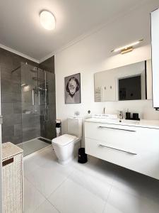 a white bathroom with a toilet and a shower at RETIRO Da CALHETA in Estreito da Calheta +14 photos