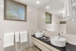 ein weißes Badezimmer mit Waschbecken und Spiegel in der Unterkunft Edges by St Bernards Hotel in Mount Tamborine + 51 Fotos