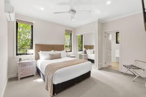 ein weißes Schlafzimmer mit einem großen Bett und einem Badezimmer in der Unterkunft Edges by St Bernards Hotel in Mount Tamborine