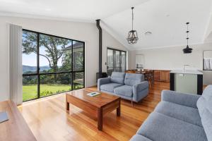 ein Wohnzimmer mit zwei Sofas und einem Tisch in der Unterkunft Edges by St Bernards Hotel in Mount Tamborine