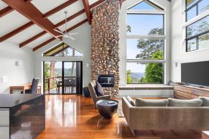 ein Wohnzimmer mit Kamin und Steinwand in der Unterkunft Edges by St Bernards Hotel in Mount Tamborine