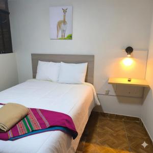 a hotel room with a bed and a deer picture on the wall at Hospedaje Samay Lodge - autogestionado in Chivay