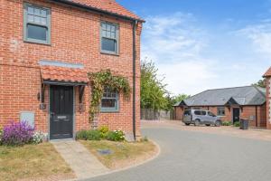 a brick house with a black door on a street at 2 Bed in Mundesley oc-r31875 in Mundesley