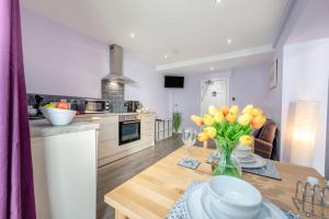 a kitchen with a table with a vase of flowers on it at 1 Bed in Tenby oc-w28986 in Tenby
