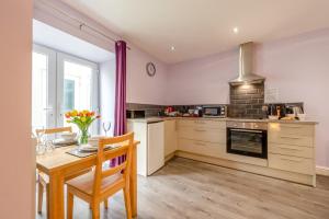 a kitchen with a wooden table and a kitchen with a stove at 1 Bed in Tenby oc-w28986 in Tenby +14 photos