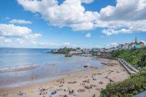 a group of people on a beach near the ocean at 1 Bed in Tenby oc-w28986 in Tenby