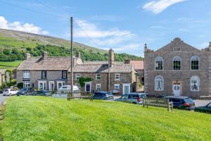 an old stone house with cars parked in a parking lot at 3 Bed in Reeth oc-l32438 in Reeth
