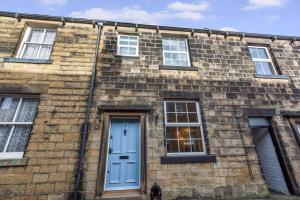 a brick building with a blue door and windows at 2 Bed in Skipton oc-ds932 in Skipton