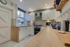 a kitchen with white cabinets and a wooden counter top at 2 Bed in Skipton oc-ds932 in Skipton