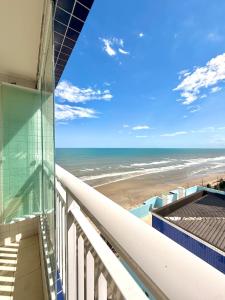 a view of the beach from the balcony of a building at Piscina Lazer Frente ao Mar in Mongaguá