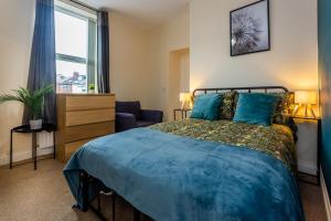 a bedroom with a blue bed and a window at Two Bed Apartment RYTON With Free Parking in Ryton
